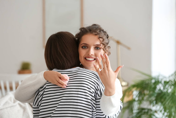 Happy engaged lesbian couple at home - Foto, Bild