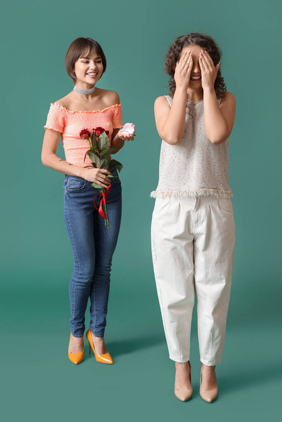 Young lesbian woman going to make proposal to her girlfriend on color background - Foto, immagini