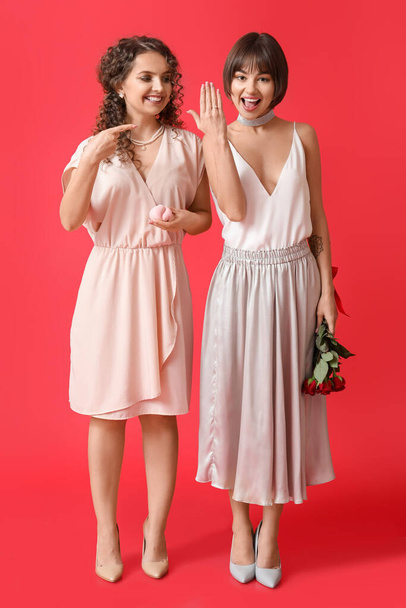 Happy engaged lesbian couple on color background - Foto, immagini