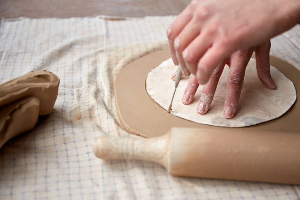 Keramička pracující v keramickém studiu. Keramické ruce Špinavé hlíny. Proces vytváření keramiky. Master keramik pracuje ve svém studiu - Fotografie, Obrázek