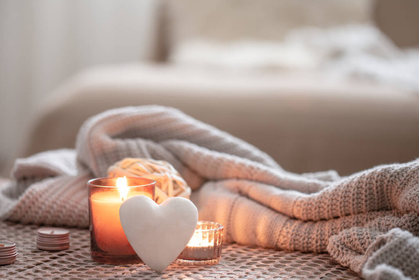 Уютный фон ко Дню Святого Валентина со свечой и декоративным сердцем. - Фото, изображение