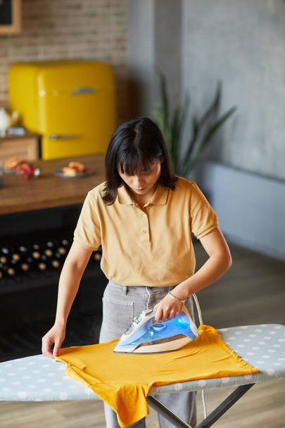 Frau bügelt Kleidung zu Hause - Foto, Bild