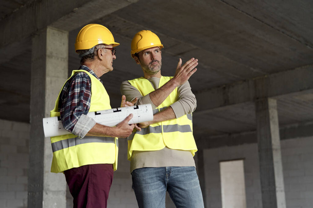 Two caucasian engineers discussing on construction site   - 写真・画像