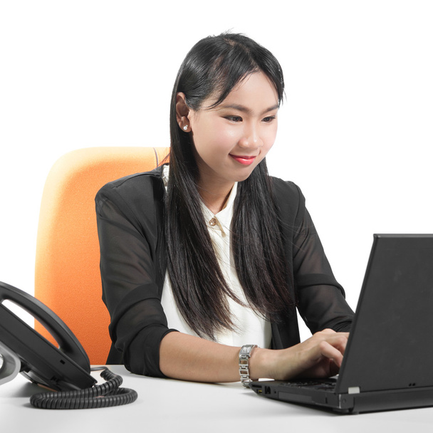 Joven mujer de negocios bastante usando ordenador portátil con el teléfono encendido
  - Foto, Imagen