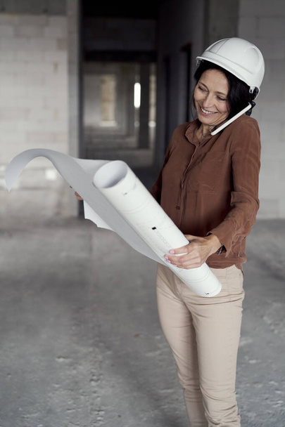 Nainen kypsä valkoihoinen insinööri kävelee rakennustyömaalla  - Valokuva, kuva