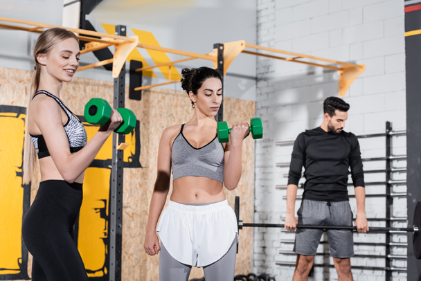 Többnemzetiségű sportoknői edzés súlyzókkal a tornateremben  - Fotó, kép