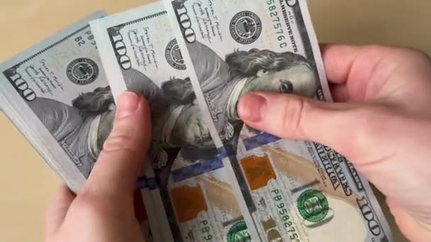  Egy ember több száz dollárt számol, pénzt tart a kezében az asztalon. - Felvétel, videó