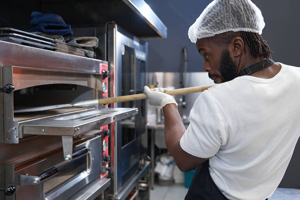 Erwachsener Koch arbeitet hart, backt Essen im Restaurant - Foto, Bild