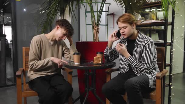 Δύο γκέι άντρες σε ραντεβού κάθονται σε ένα καφέ. Ο τύπος μιλάει στο τηλέφωνο και ο άλλος είναι προσβεβλημένος από αυτόν. ΛΟΑΤ - Πλάνα, βίντεο