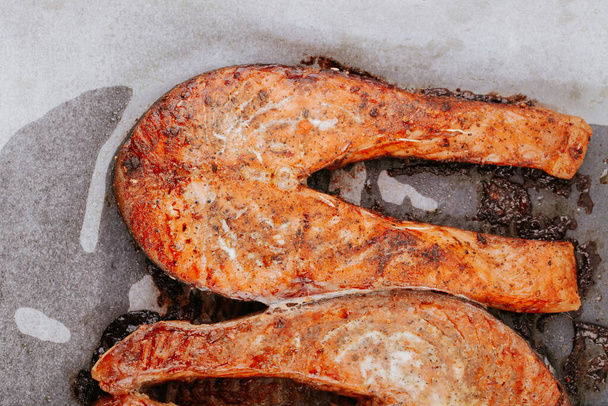 Cooked salmon steaks on a baking sheet close-up. Steaks of red fried fish. Pieces of baked salmon - Fotoğraf, Görsel