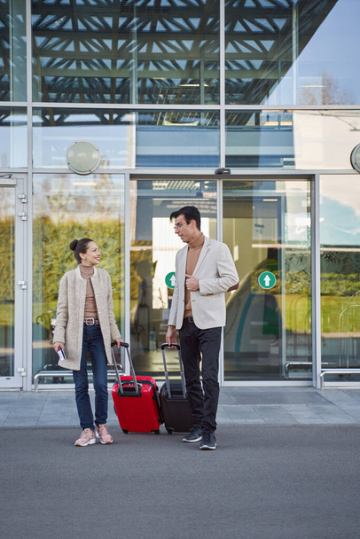 Couple staying near airport entrance with luggage - Φωτογραφία, εικόνα