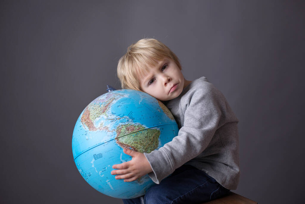 Cute toddler child, boy, hugging big globe, isolated image - Foto, Imagem