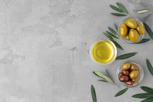 Flatlay composition of olives and olive oil on gray background - Foto, Bild