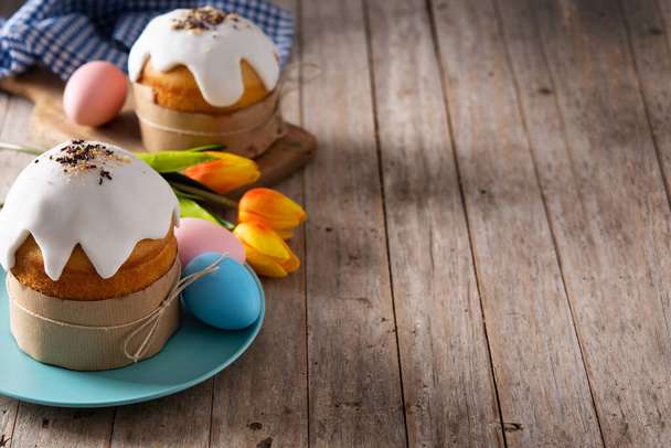 Traditional Easter cake, colorful eggs and tulips on wooden table. Copy space - Foto, Imagen