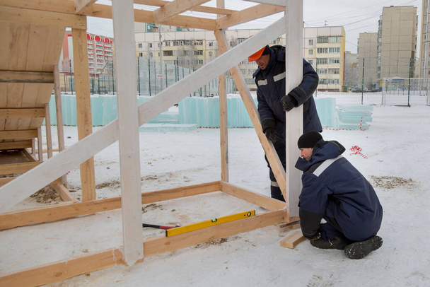 Dos trabajadores montan el marco de la diapositiva de vigas de madera - Foto, imagen