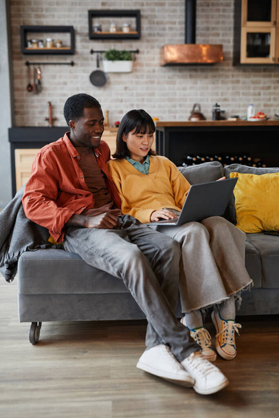 ζευγάρι χρησιμοποιώντας φορητό υπολογιστή στον καναπέ - Φωτογραφία, εικόνα