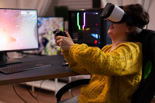 Donna gamer indossando occhiali realtà virtuale tenendo joystick giocare sparatutto spaziale videogiochi - Foto, immagini