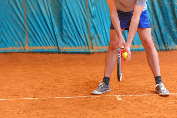 Tennis player holding racket and yellow ball ready to serve - Foto, Imagem