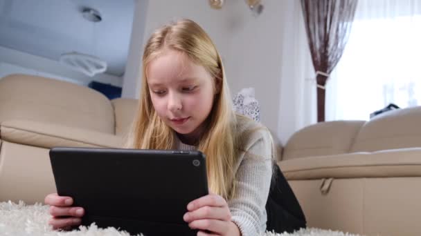 女の子は自宅でiPadタブレットで遊ぶ - 映像、動画