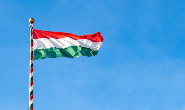 Hungarian flag or flag of Hungary waving against blue sky, space for text - Fotoğraf, Görsel