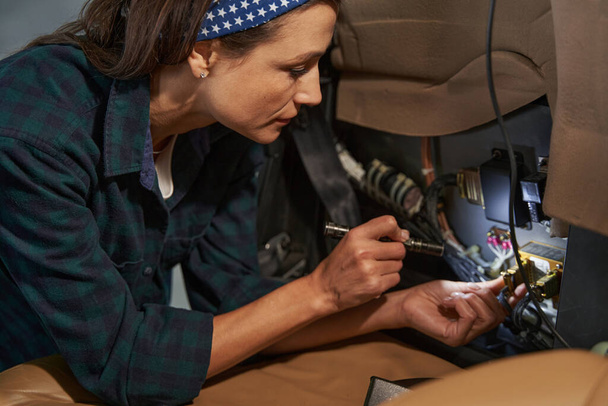 Poważnie brunetka kobieta mechanik jest naprawy samolotów - Zdjęcie, obraz
