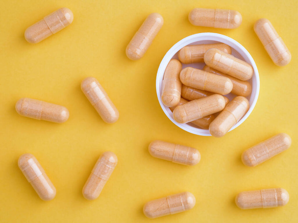 Vitamin B complex capsules in a cap with other vitamin b complex capsules around them. Close up. - Foto, imagen