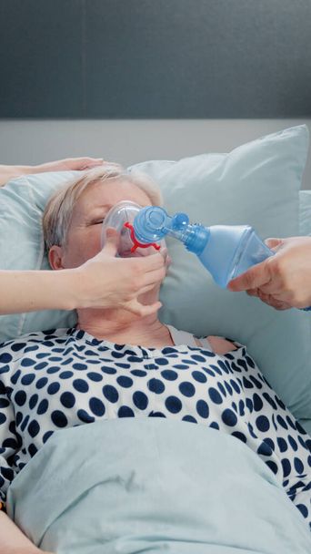 Doctor and nurse using oxygen tube for hyperventilating woman - Фото, зображення