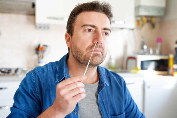 Ein Mann checkt Coronavirus-Infektion zu Hause mit Antigen-Kit - Foto, Bild