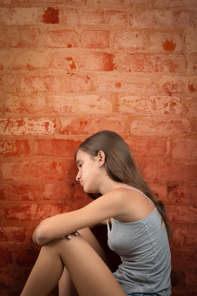 Sad and lonely teenage girl sitting on the floor - Foto, Bild