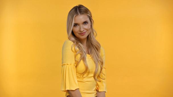 Pretty blonde woman looking at camera isolated on yellow - Zdjęcie, obraz
