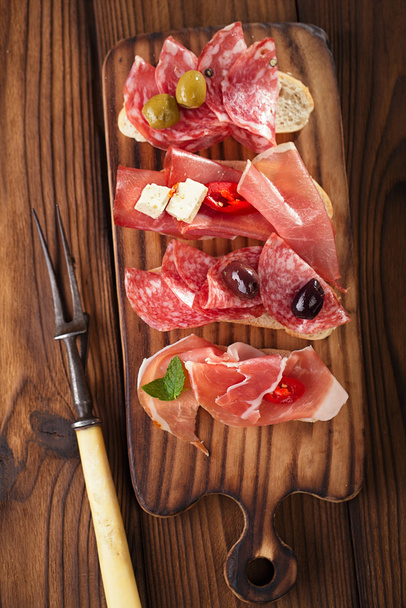Assiette antipasti de viande salée, jamon, olives, saucisse, salam
 - Photo, image