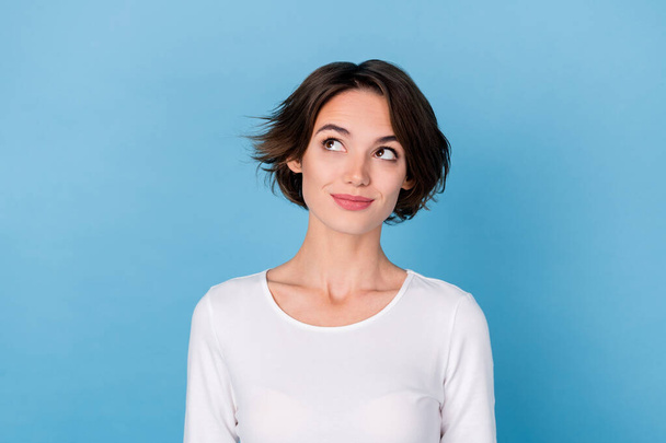 Photo of dreamy adorable young woman wear white shirt smiling looking empty space isolated blue color background - Fotografie, Obrázek