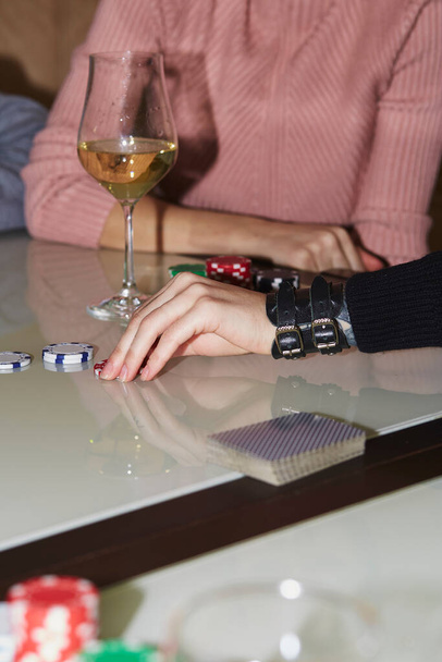 Woman hand make a move with dice in poker game. Cards, dices and glasess of champagne. Candid moment. Poker background lifestyle photography. Enjoying the moment, digital detox with friends. - Photo, Image