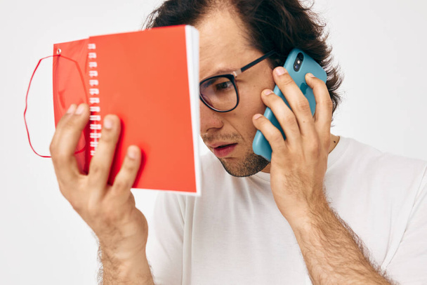 Cheerful man red notepad telephone communication Lifestyle unaltered - 写真・画像
