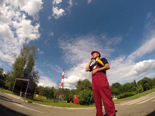 Промышленный работник в красной шляпе с помощью мобильного телефона
 - Фото, изображение