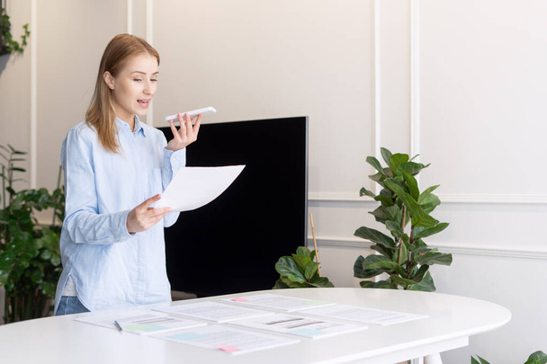 Portrait of beautiful and confident woman with documents talking to client on phone. Home office. Business problems resolving. Communication with customer using gadget - Photo, Image