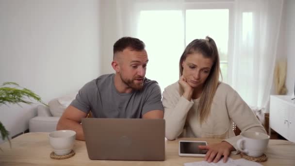 felice coppia caucasica seduto a tavola impegnarsi in affari utilizzando il computer portatile - Filmati, video