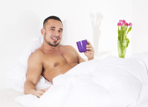 hombre en la cama con taza
 - Foto, Imagen
