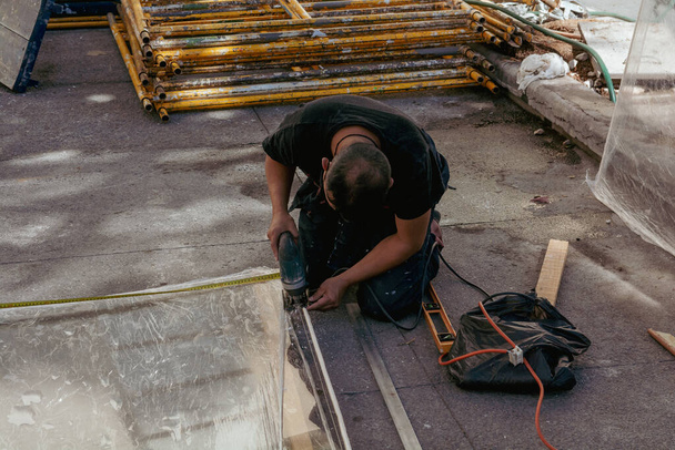 Bricklayer cutting a piece of mica for installation in a classroom. - Фото, зображення
