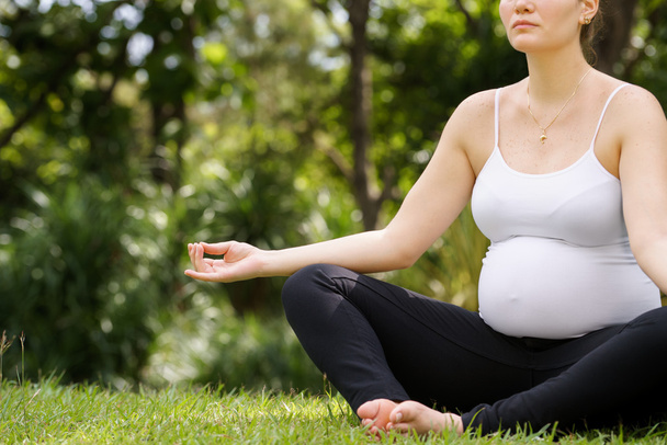 Mulher grávida mãe barriga relaxante parque ioga lótus
 - Foto, Imagem