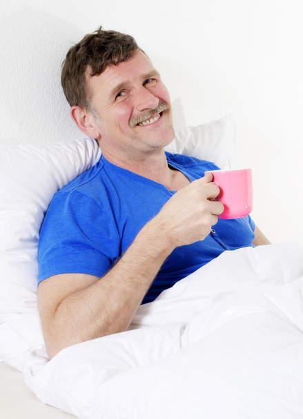 man in bed with cup - Valokuva, kuva