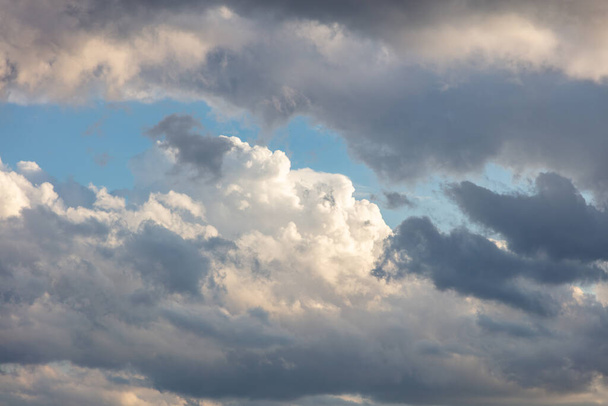 Cumulus cloudscape λευκό γκρι χρώμα και πορτοκαλί απόχρωση. Ανατολή πολύχρωμο σύννεφο στο μπλε φόντο του ουρανού. Ηλιόλουστο χρώμα ο συννεφιασμένος ουρανός. Λυκόφως, αυγή tim - Φωτογραφία, εικόνα