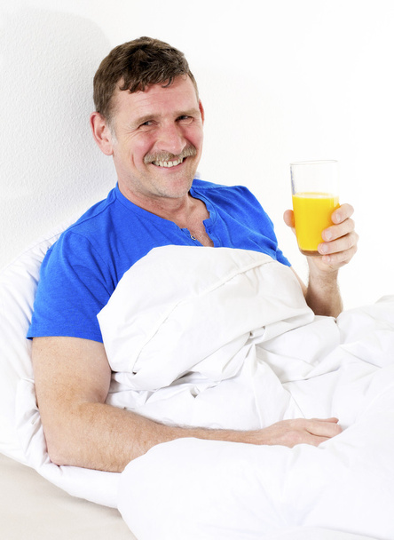 man in bed with orange juice - Photo, Image
