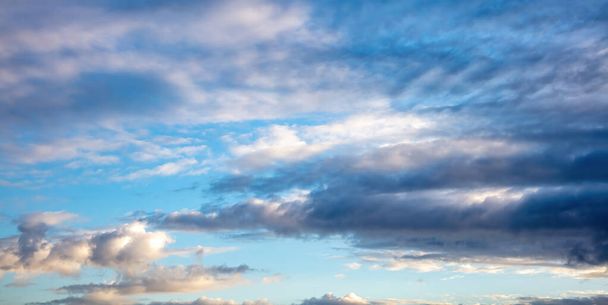 Zonsopgang kleurrijke wolk op blauwe lucht achtergrond. Cumulus cloudscape witte grijze kleur en oranje schaduw. Zonsondergang licht kleur de bewolkte hemel. Twilight, dageraad tijd - Foto, afbeelding