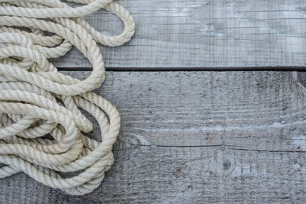 Vieille corde tordue et attachée dans un faisceau sur un backgrou en bois rugueux
 - Photo, image