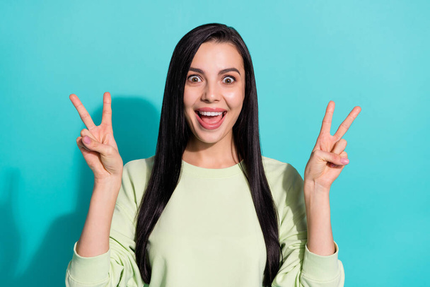 Portrait of shocked surprised lady unexpected meet friend make v sign isolated over cyan color background - Фото, изображение