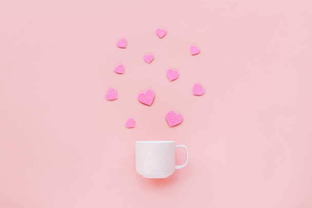 A cup on a pink background with hearts flying out of it. Valentines day concept. Top view. - Zdjęcie, obraz
