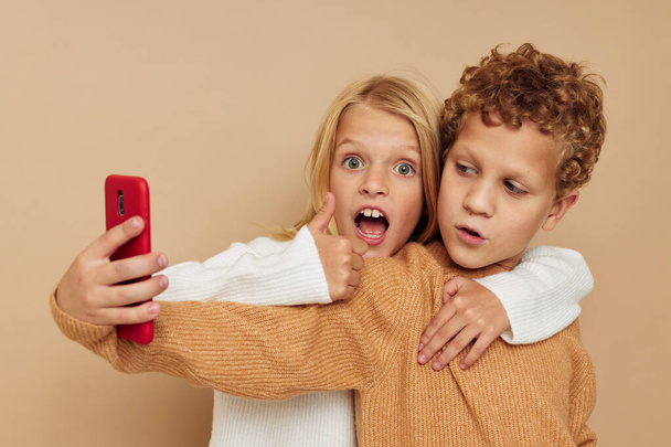 Portrait of cute children hug entertainment selfie posing friendship beige background - Foto, imagen