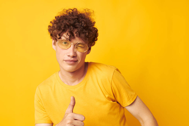 cute red-haired guy wearing stylish glasses yellow t-shirt posing yellow background unaltered - Foto, Bild