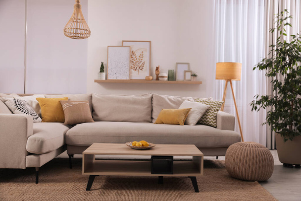 Stylish living room interior with comfortable grey sofa and coffee table - Foto, afbeelding